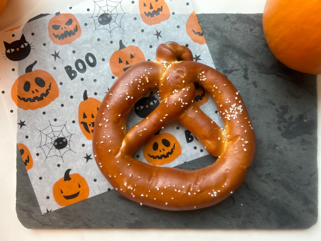 Pretzel twist in the shape of a pumpkin with a Halloween napkin on a countertop