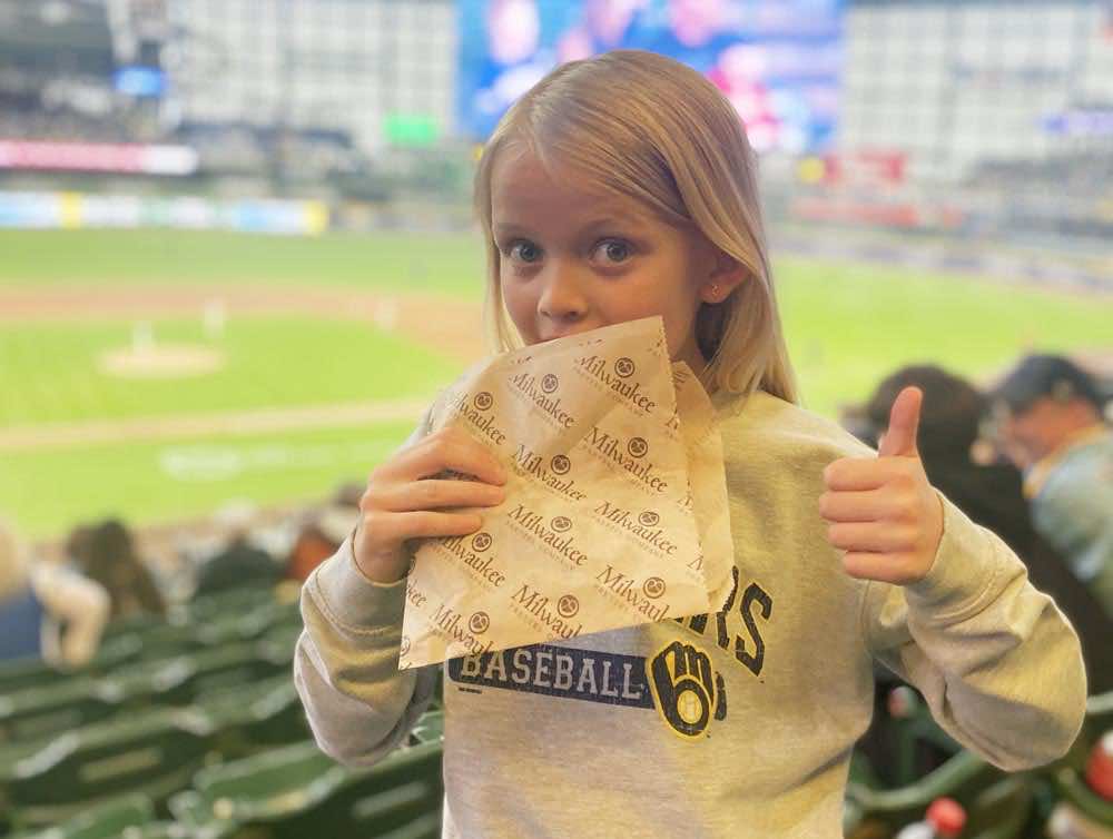 A child eating a pretzel at a baseball game