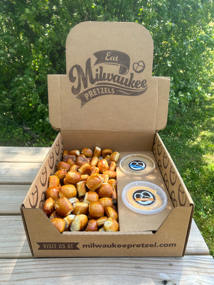 One Hundred (100) pretzel bites salted and ready to eat in a catering box with 2 different dips