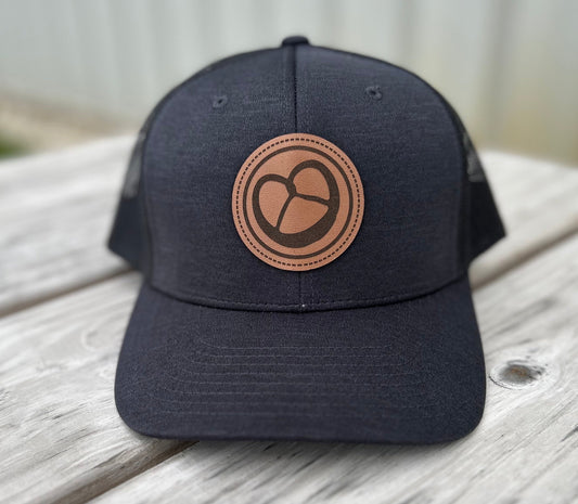 Milwaukee Pretzel Company patch trucker hat in black with a pretzel logo